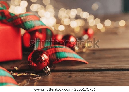 Gift boxes with a large red bow against a background bokeh of twinkling party lights. Luxury New Year gift. Christmas gift. Christmas background with gift box. Christmastime celebration