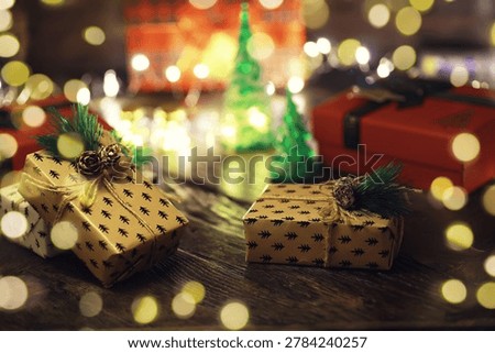 Gift boxes with a large red bow  against a background bokeh of twinkling party lights. Luxury New Year gift. Christmas gift. Christmas background with gift box. Christmastime celebration