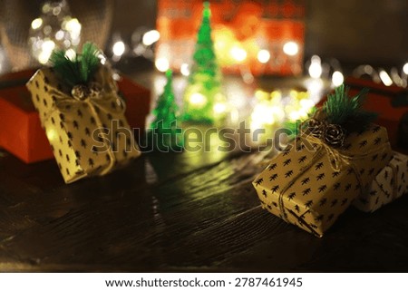 Gift boxes with a large red bow  against a background bokeh of twinkling party lights. Luxury New Year gift. Christmas gift. Christmas background with gift box. Christmastime celebration