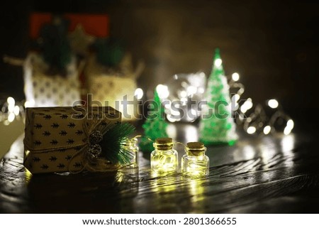 Gift boxes with a large red bow  against a background bokeh of twinkling party lights. Luxury New Year gift. Christmas gift. Christmas background with gift box. Christmastime celebration