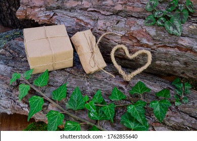 Gift boxes made of kraft paper, handmade heart of jute and the sprig of ivy on bark of tree. Greeting card. international women's day. ecology, handmade, romance, valentines day and holidays concept - Powered by Shutterstock