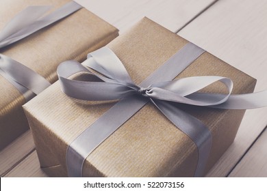 Gift boxes on white wood background. Presents in gold paper decorated with stylish elegant silver satin ribbon bows. Christmas and any other holidays concept - Powered by Shutterstock