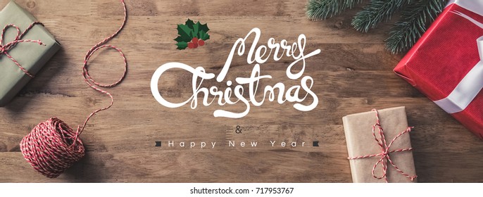 Gift Boxes On A Wooden Table With Merry Christmas And Happy New Year Greeting Texts - Horizontal Web Banner