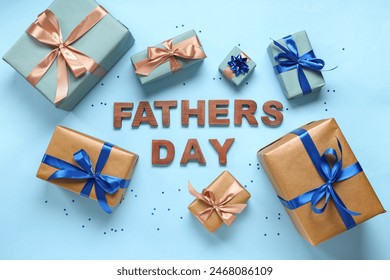 Gift boxes and text FATHERS DAY made with wooden letters on blue background. Top view - Powered by Shutterstock