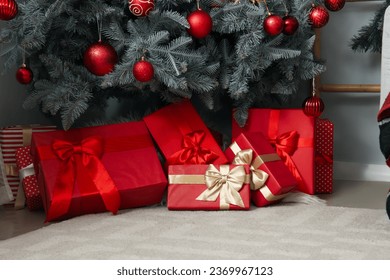Gift boxes under Christmas tree in living room