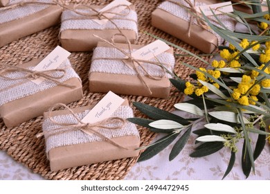 Gift boxes wrapped craft paper jute ribbon and thank you tag, rustic wedding favors country theme decoration, wicker background, green leaves yellow flowers, spring summer autumn style event souvenirs