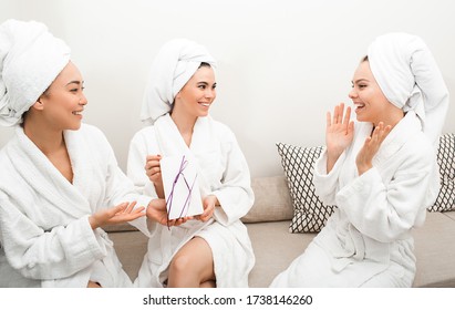 Gift Card Certificate At The Spa. Women Give A Certificate To Their Girlfriend, Spa Services, Body Treatments. Women In Bathrobes Enjoying Relaxing At The Spa