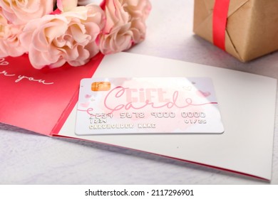 Gift Card, Flowers And Present On Light Table, Closeup