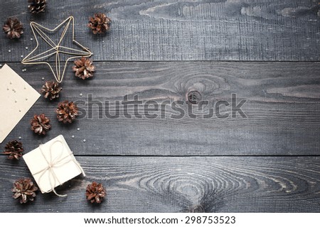 Gift, card, pine cones, metal star on the dark wooden textured table