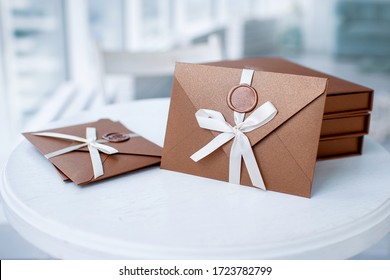 Gift Certificate, Gift Voucher Or Discount. Close-up Photo Of Bronze Invitation Envelope With A Ribbon And Wax Seal, A Gift Certificate, A Card, A Wedding Invitation Card