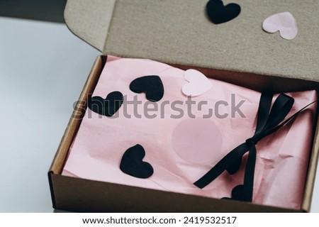 gift kraft box with pink wrapping paper and black ribbon. mockup preparation for Valentine's Day. gifts and packaging are made by our own hands
