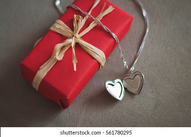 a gift and a pendant in the shape of a heart for Valentine's day