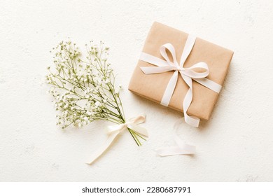 Gift or present box and flower gypsophila on light table top view. Greeting card. Flat lay style with copy space. - Shutterstock ID 2280687991