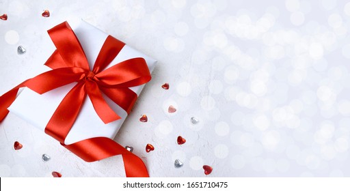 Gift And Red Hearts  On White Background. Greeting Concept For Valentines Day, Mothers Day, Women Day Or Wedding. Bokeh Lights. Banner With Copyspace.