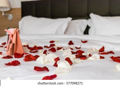 Gift With Rose Petals On The Bed