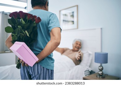 Gift, surprise and a senior couple on their anniversary in the bedroom of their house together for celebration in the morning. Flowers, birthday box and an old man giving his wife a present at home - Powered by Shutterstock