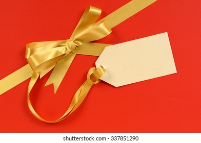 Gift Tag On Red Christmas Gift Background With Gold Ribbon Bow Diagonal