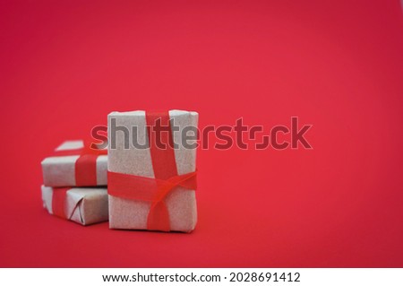 gift in wrapped paper on red background holiday mood
