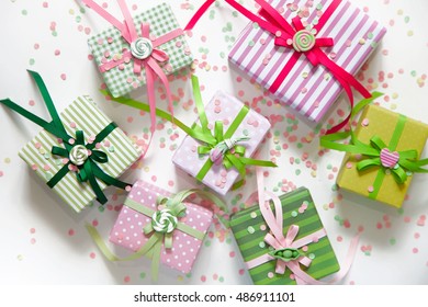 Gift Wrapped In Paper. Small Gifts Are Packed In Colored Paper. Colored Ribbons. Gift Wrapping. View From Above. Pastel Shades.