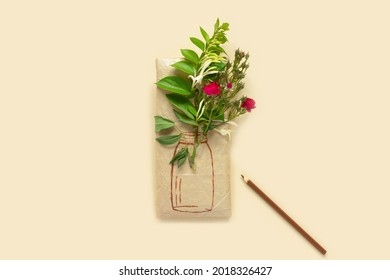 Gift wrapped in wrapping paper and bouquet crimson roses   painted vase  Honeysuckle branches for decoration   pencil yellow background  Flat lay  top view concept and copy space 