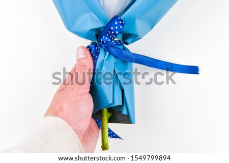 Gift wrapping for flowers. Bottom part. Place for an inscription. Easy to cut. View from above. close-up. Hand holds a bouquet of flowers. Floristry concept.