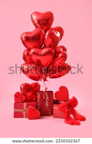 Gifts with heart-shaped balloons for Valentine's Day on pink background