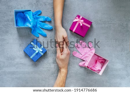 Gifts of love. A man and a woman hold hands, next to open pink and blue gift boxes with gloves inside. Advertising background. Gifts. Valentine's Day, Wedding anniversary.