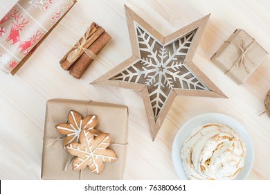 Gifts and presents scandinavian style wrapped in brown craft paper. Ginger cookies, cinnamon and sweet sugar bun make the gift preparing sweeter