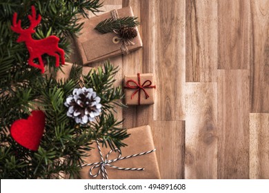 Gifts Under Christmas Tree On Wooden Floor. Top View With Copy Space.