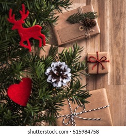 Gifts Under Christmas Tree Over Wooden Floor. Top View With Copy Space.