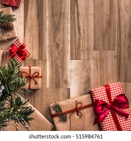 Gifts Under Christmas Tree Over Wooden Floor. Top View With Copy Space.