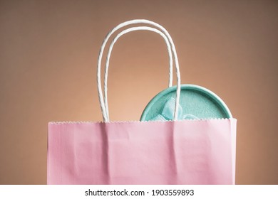 Gifts Are Visible From The Pink Gift Bag. Blue Round Box. The Background Color Is Dark Beige, Vignetted.