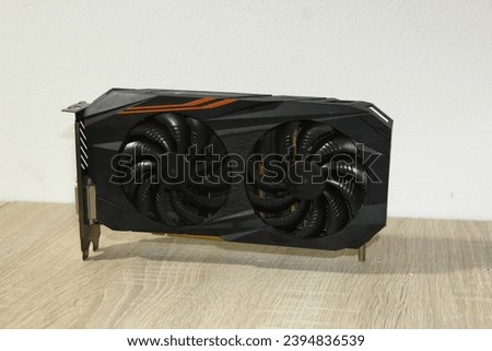 Gigabyte gaming gpu graphich card photo white and wood backround. Orange black gpu card with coolers. Photo for sample of selling card.