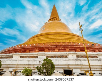The Gigantic Pagoda, namely Pra Phathom Chedi, with the corridor on its base in a blur foreground of a lamp posts,  inside the Buddhist temple of Nakorn Pathom provice, Thailand