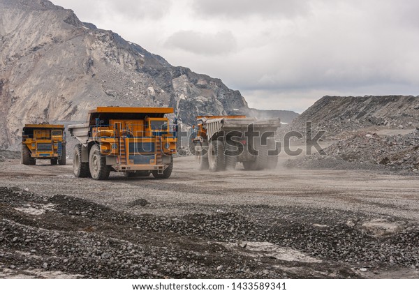 Gigat dump trucks are working in the\
mine for the production of apatite in the Murmansk region carrying\
rock. Extraction of minerals in the harsh\
highlands.
