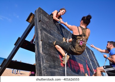 GIJON, SPAIN - SEPTEMBER 19: Storm Race, an extreme obstacle course in September 19, 2015 in Gijon, Spain. Participants in extreme obstacle course jumping a wooden wall.