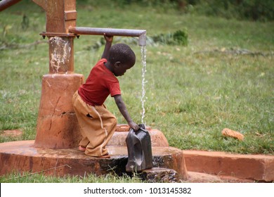 Gilgil, Nakuru County Kenya, November 23 2017, Small Child Filling A Jug Of Water From The Local School Well. Many Families Do Not Have Access To Clean Water At Home And Carry It For Long Distances. 