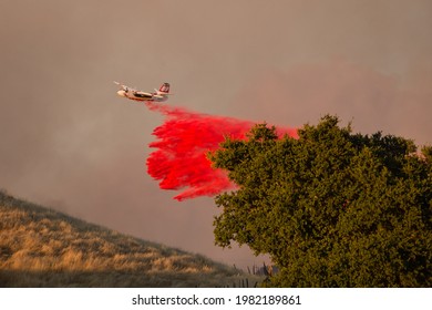 GILROY, CALIFORNIA - JULY 5, 2020: A CAL FIRE Tanker Plane Drops Fire Retardant Ahead Of The Fast-moving Crews Fire.