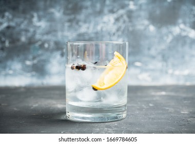 Gin based cocktail with lemon slice and juniper berries. Selective focus. Shallow depth of field.
