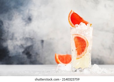 Gin Bitter Lemon Trendy Alcoholic Cocktail Drink With Dry Gin, Tonic, Grapefruit And Ice Cubes. Gray Background With Copy Space