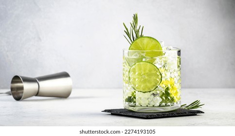 Gin tonic classic cocktail drink with dry gin, bitter tonic, lime and ice. Gray table background  - Powered by Shutterstock