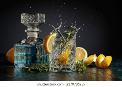 Gin tonic cocktail with lemon and rosemary. Slice of lemon fall in glass with a cocktail. - Shutterstock ID 2179786255