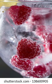 Gin Tonic Cocktail With Raspberry And Ice Macro Bubbles Closeup On Black