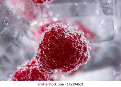 Gin Tonic Cocktail With Raspberry And Ice Macro Bubbles Closeup On Black