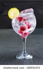 Gin Tonic Cocktail With Raspberry Lima Slice And Ice On Black