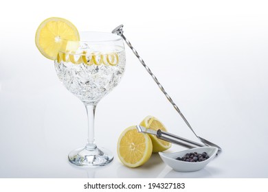 Gin And Tonic In A Highball Cup Garnished With A Lemon Wedge And Twist