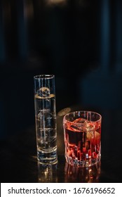 Gin Tonic In A Highball Glass And Cocktail Based On Rose Porto Wine And Japanese Sake In A Rocks Glass. Dark Background. Smooth Image With Shallow Depth Of Field. 