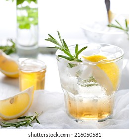 Gin, Tonic, Lemon, Rosemary Fizz, Cocktail With Honey And Fresh Herbs On A White Background. 