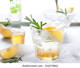 Gin, Tonic, Lemon, Rosemary Fizz, Cocktail With Honey And Fresh Herbs On A White Background.