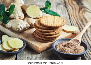 Ginger biscuits served with ginger root and grounded powder. Fresh ginger biscuits served with ginger roots and grounded powder on wooden table.